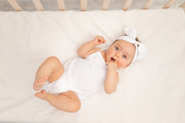 Baby girl lying in the crib in the nursery