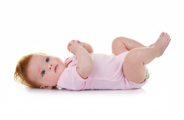 Baby girl lying on white 