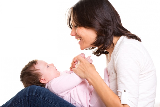 Baby girl on mother jeans knees playing together