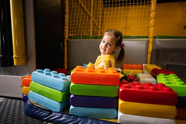 Baby girl playing with colored blocks at kindergarten