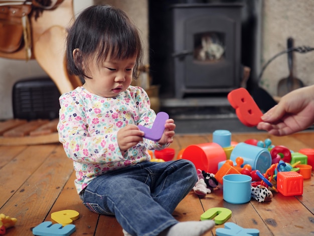 Photo baby girl playing with toys at home