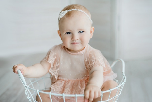 Baby girl posing in a vintage basket.
