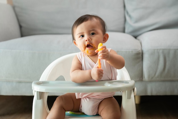 ベビーチェアでブレンド食品を食べる準備ができている女の赤ちゃん