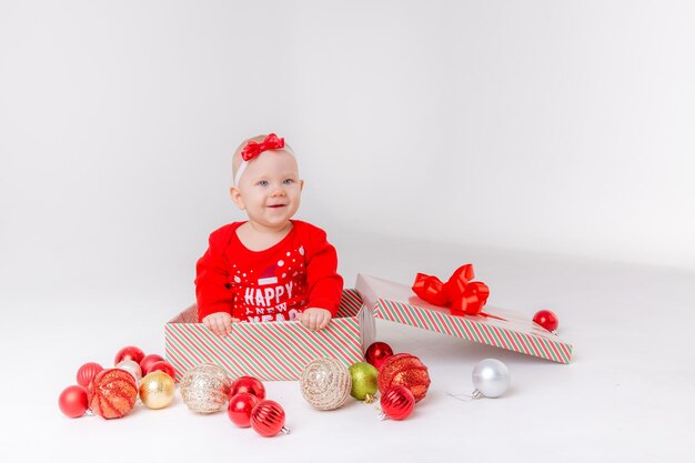 Baby girl in Santa costume in a gift box on a white background Christmas Gift