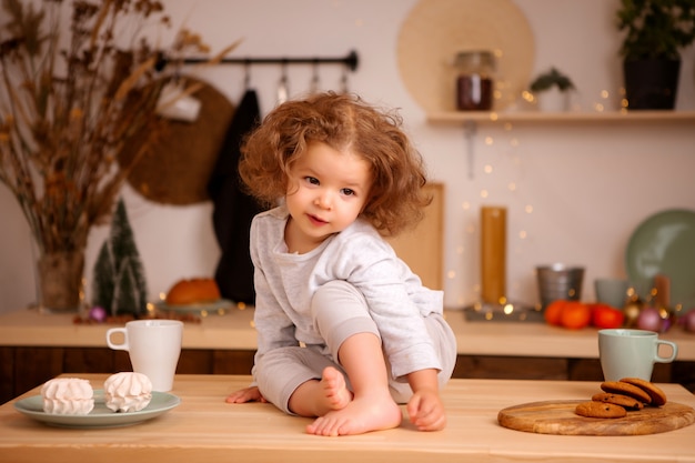 baby girl sitting in Christmas kitchen on table