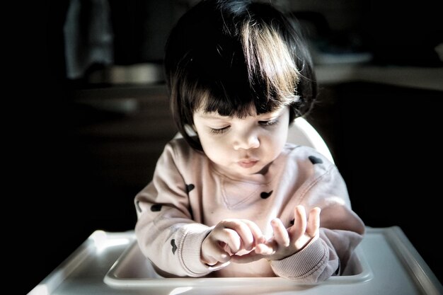 写真 家で高い椅子に座っている赤ちゃん