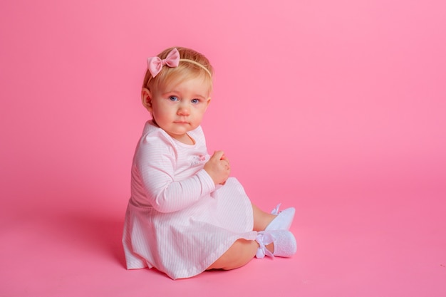 Baby girl sitting on pink 