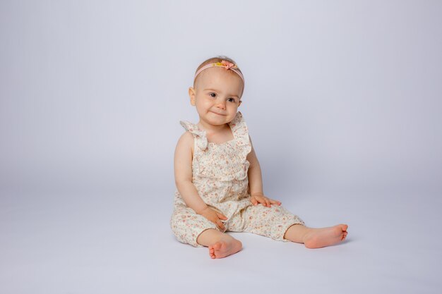 Baby girl sitting on a white background isolated