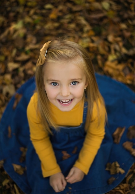 Bambina, sorridi, cadi, seduta per terra, versando