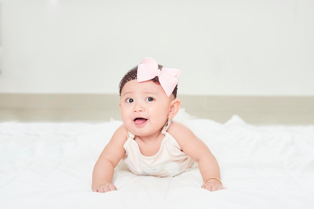 Baby girl smiling on the floor isolated on white