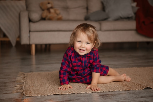 Baby girl smiling playing on the floor of the house. stay home