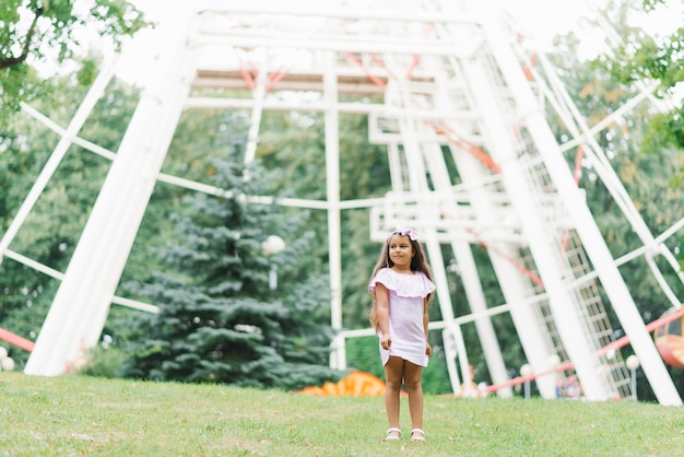 Baby girl spinning in an amusement park in summer