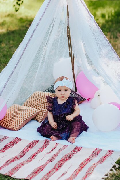 baby girl in violet dress having fun in garden