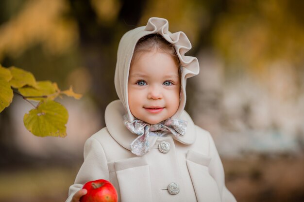 Bambina in una passeggiata nel parco in autunno