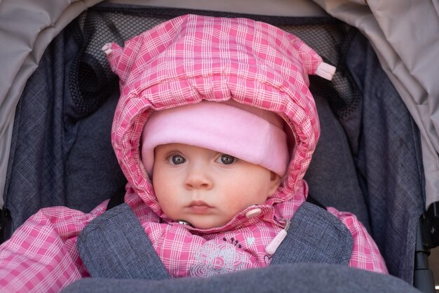 ベビーカーに座って散歩中の女の赤ちゃん