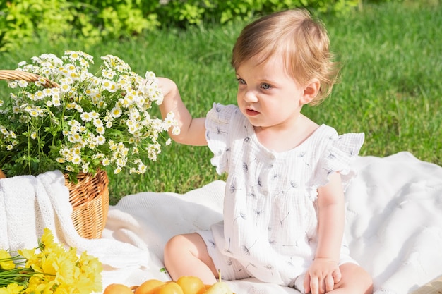 Photo baby girl with a basket of flowers