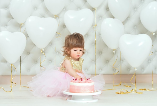 彼女の誕生日にケーキを持つ女の赤ちゃん