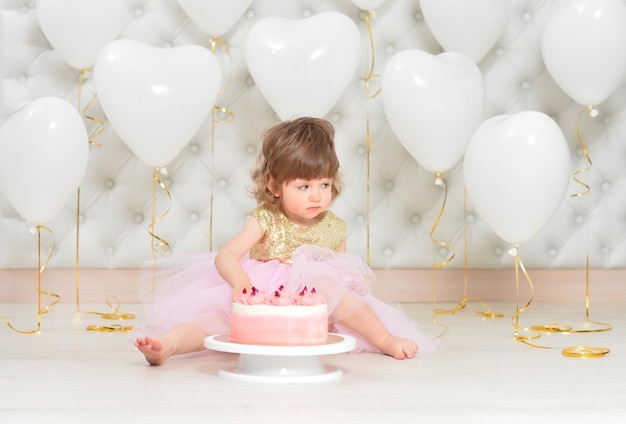 彼女の誕生日にケーキを持つ女の赤ちゃん