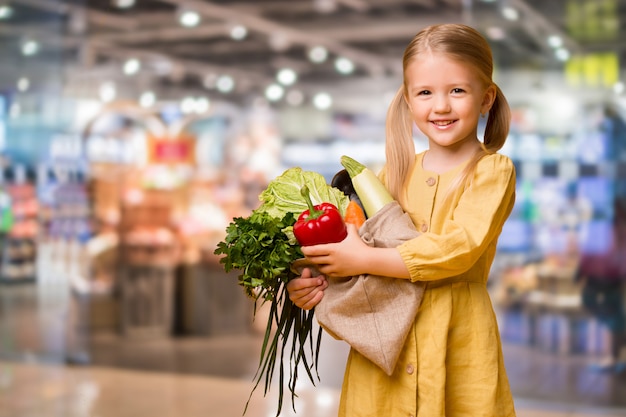 baby girl with eco bag and vegetables