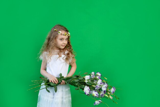 Baby girl with flowers on a green background