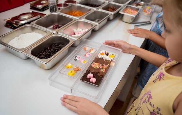 Baby girl in the workshop during a lesson on making handmade chocolates and sweets