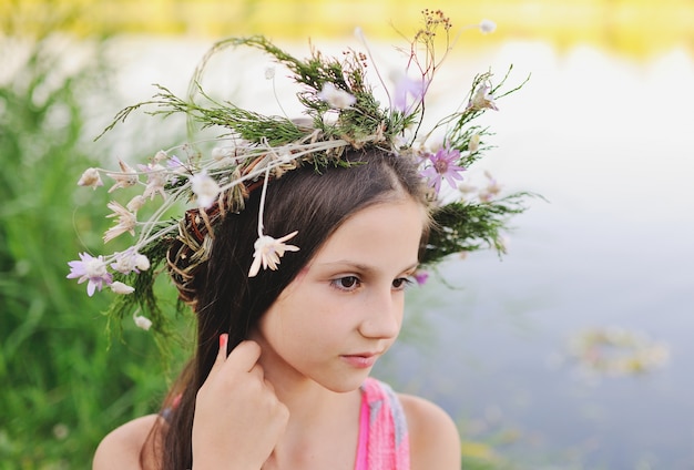 野生の花の花輪の女の赤ちゃん