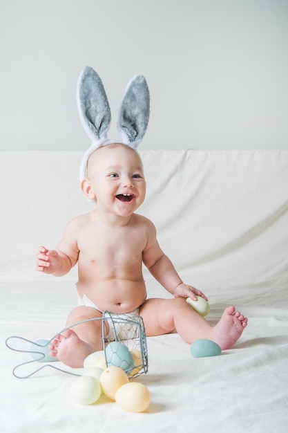 Baby girl year old on bed with basket and easter eggs egg hunting kids activity