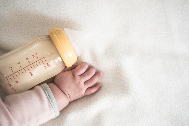 Baby hand and Bottle of Mother breast milk 