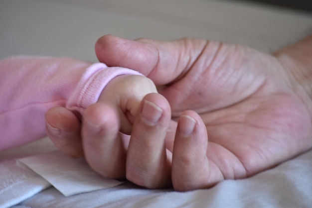 Baby hand with her grandfather