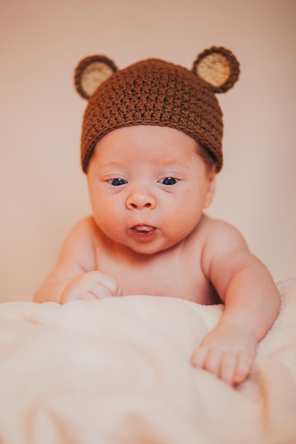 A baby in a hat on a blanket