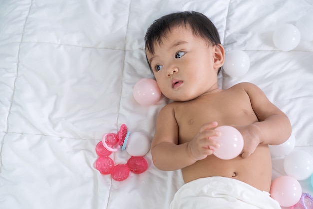 Baby het spelen kleurenbal op een bed