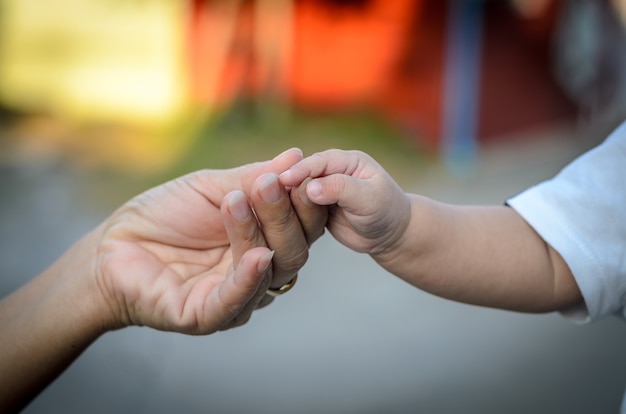 Il bambino tiene la mano di sua madre, madre e figlia si tengono per mano.