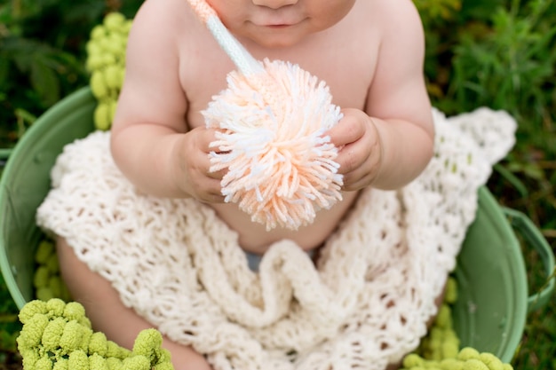 A baby holding a ball of yarn