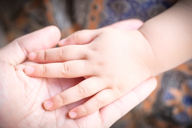 Photo baby holding father's hand