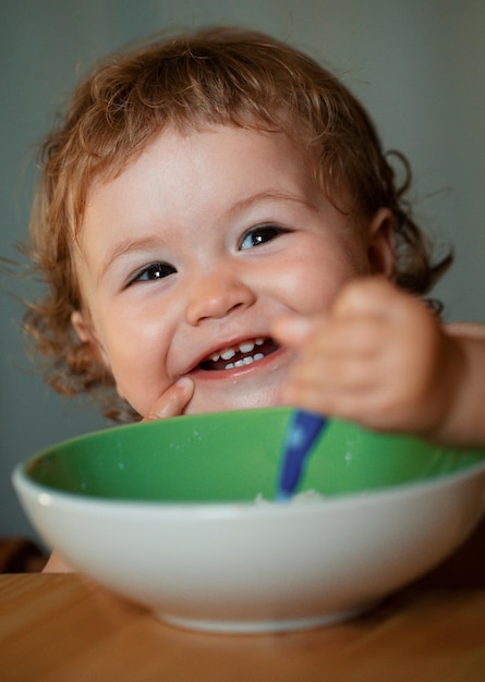 Baby holding a spoon in his mouth happy child eating himself with a spoon launching child eating foo