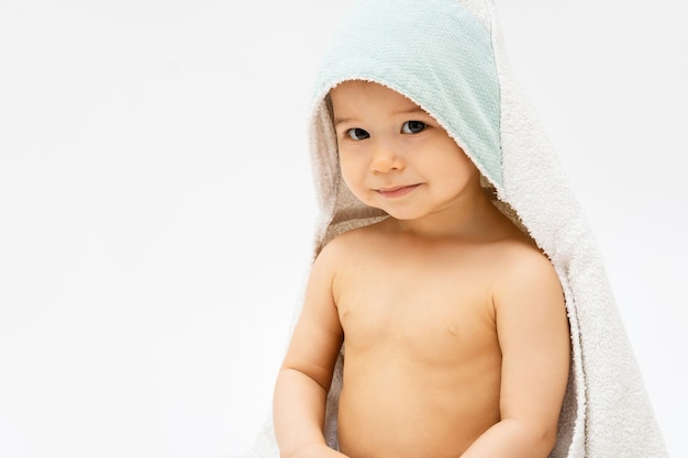 赤ちゃんの衛生とケア。入浴後のフード付きタオルでかわいい幼児男の子。