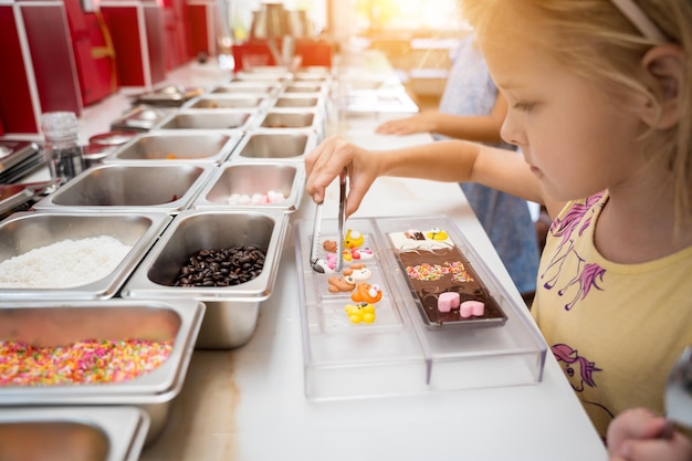 Foto baby in de werkplaats tijdens een les over het maken van handgemaakte chocolade en snoep