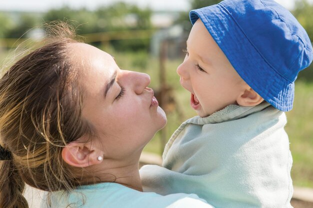 Baby in een blauwe hoed en een handdoek op de handen van mama