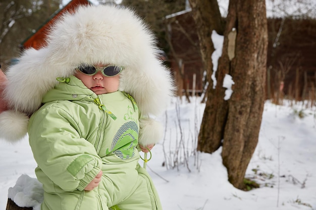 Baby in een bontmuts in de winter. winterwandeling.