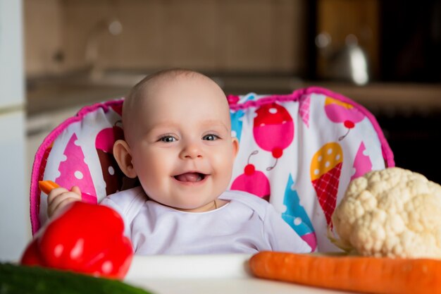 baby in een kinderzitje dat groenten eet