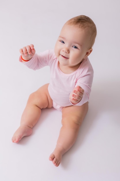 baby in een roze bodysuit zit op de vloer bovenaanzicht ruimte voor tekst Hoge kwaliteit foto