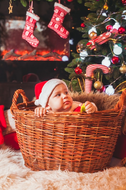 Baby in kerstmankostuum spelen bij kerstversiering