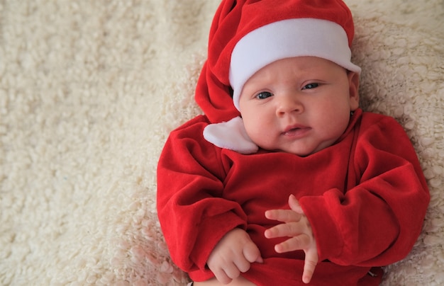 baby in santa kostuum op witte achtergrond. Kerst peuter in kerstmuts