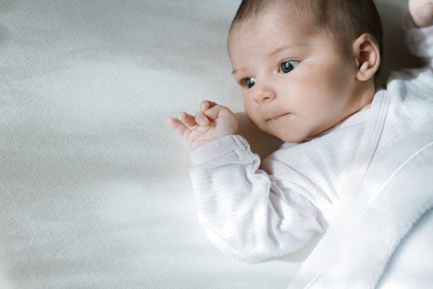 baby in witte zonnige slaapkamer die in bed rust Familieochtend thuis