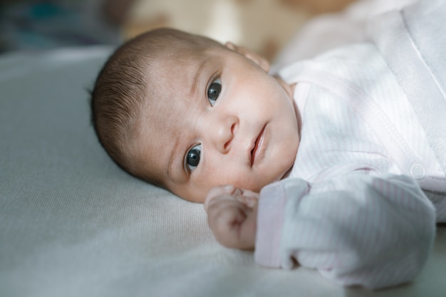 Baby in witte zonnige slaapkamer die in bed rust familieochtend thuis