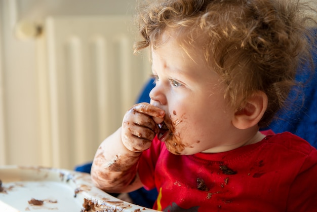 Baby is eating a chocolate cake