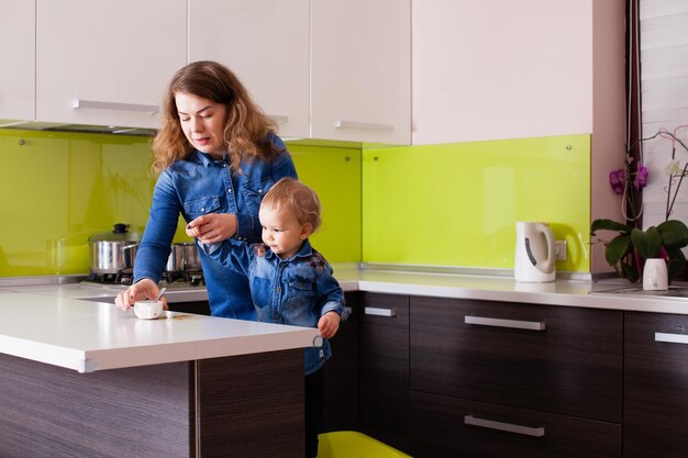 Baby is een beetje koffie aan het inschenken in de keuken