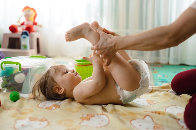 A baby is getting a massage from her mother