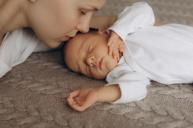 a baby is laying on a blanket with a woman in a white shirt