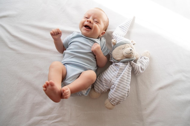 The baby is lying in his crib and looking at the camera A happy child Children's article